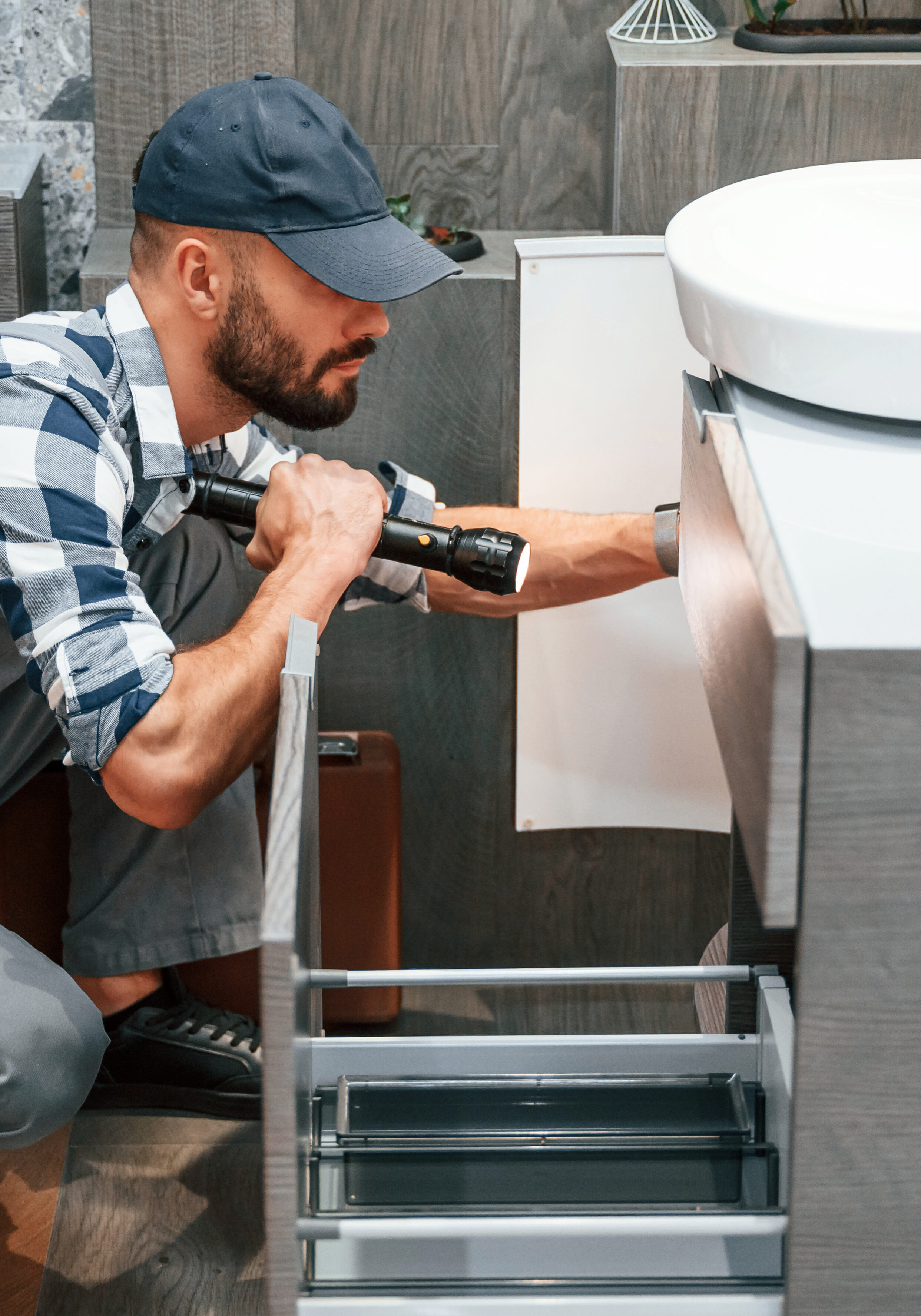 Plumber in uniform is working indoors Plumber in uniform is working indoors