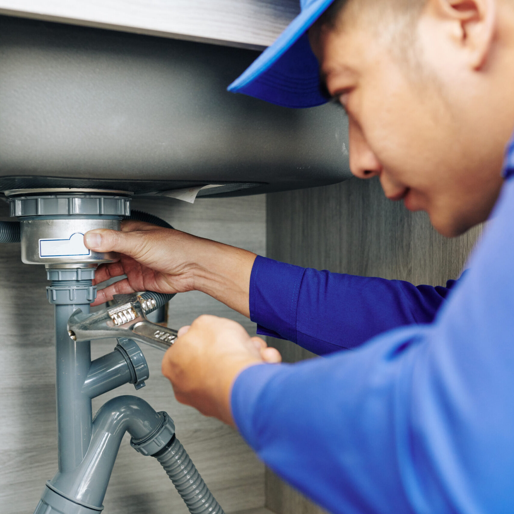 Plumber repairing a leaky drain Plumber repairing a leaky drain